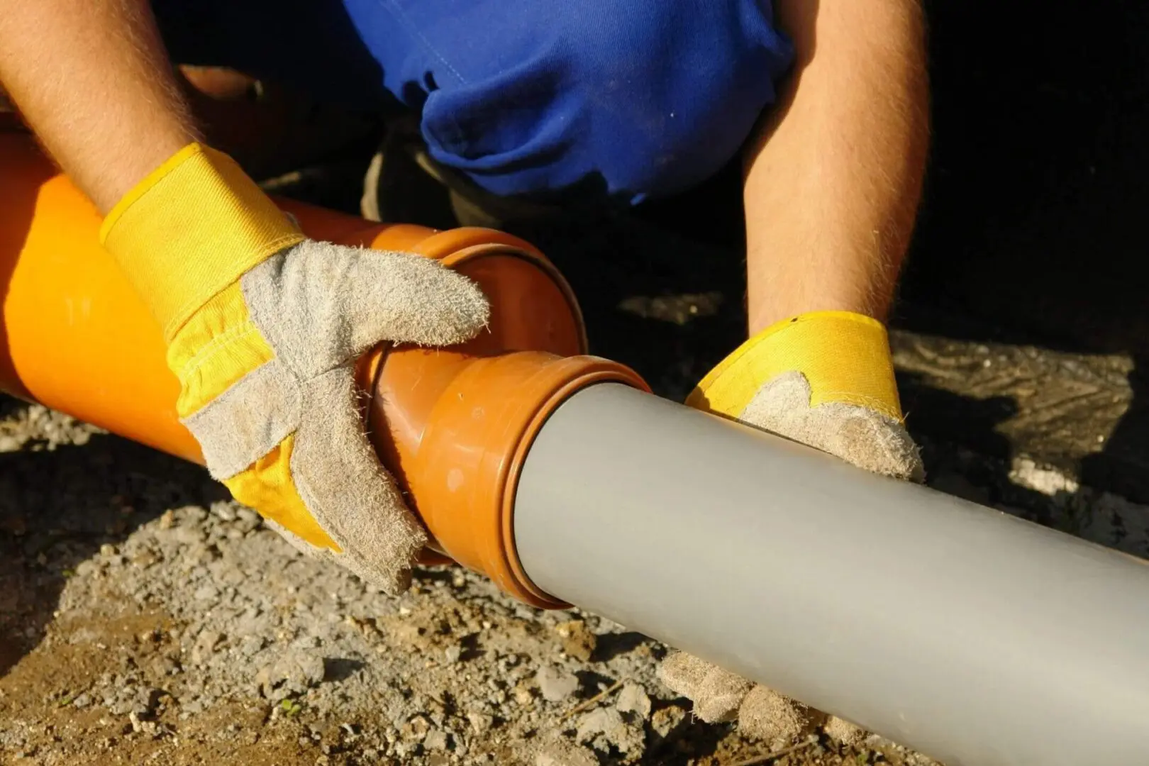 Plumber adjusting the middle part of the pipe